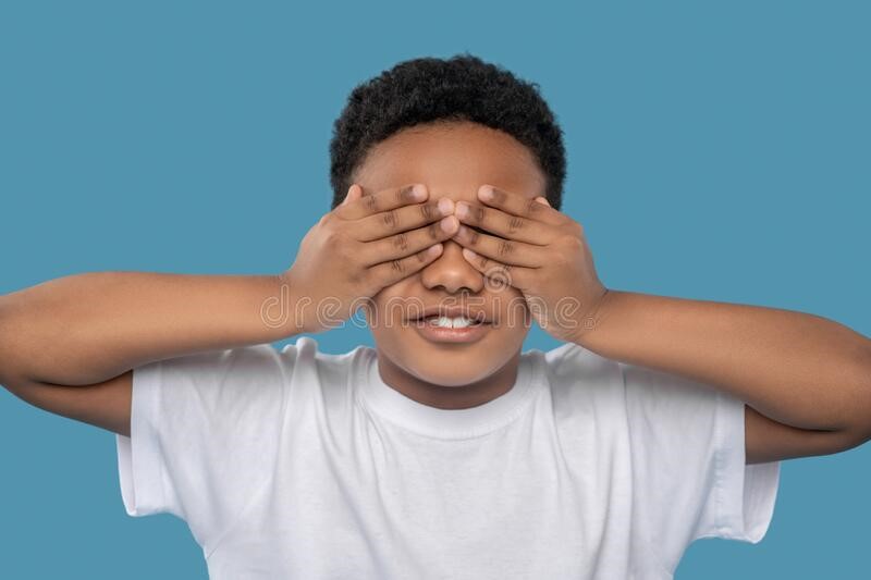 African kid covering his eyes with his hands